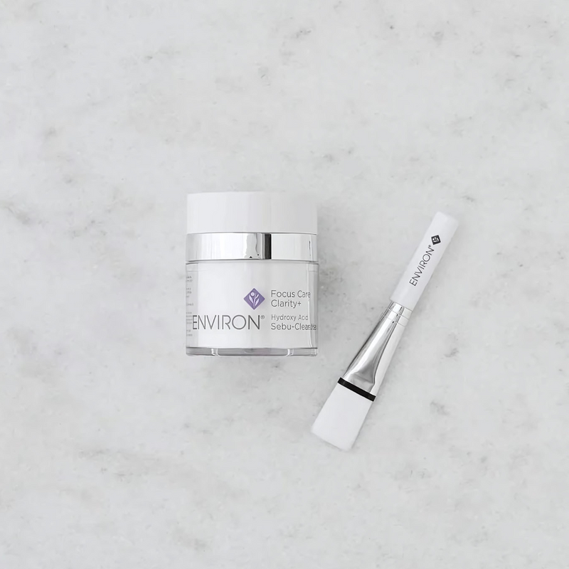 Environ Hydroxy Acid Sebu-Clear Masque in a white jar with a silver lid, featuring the product label and packaging.